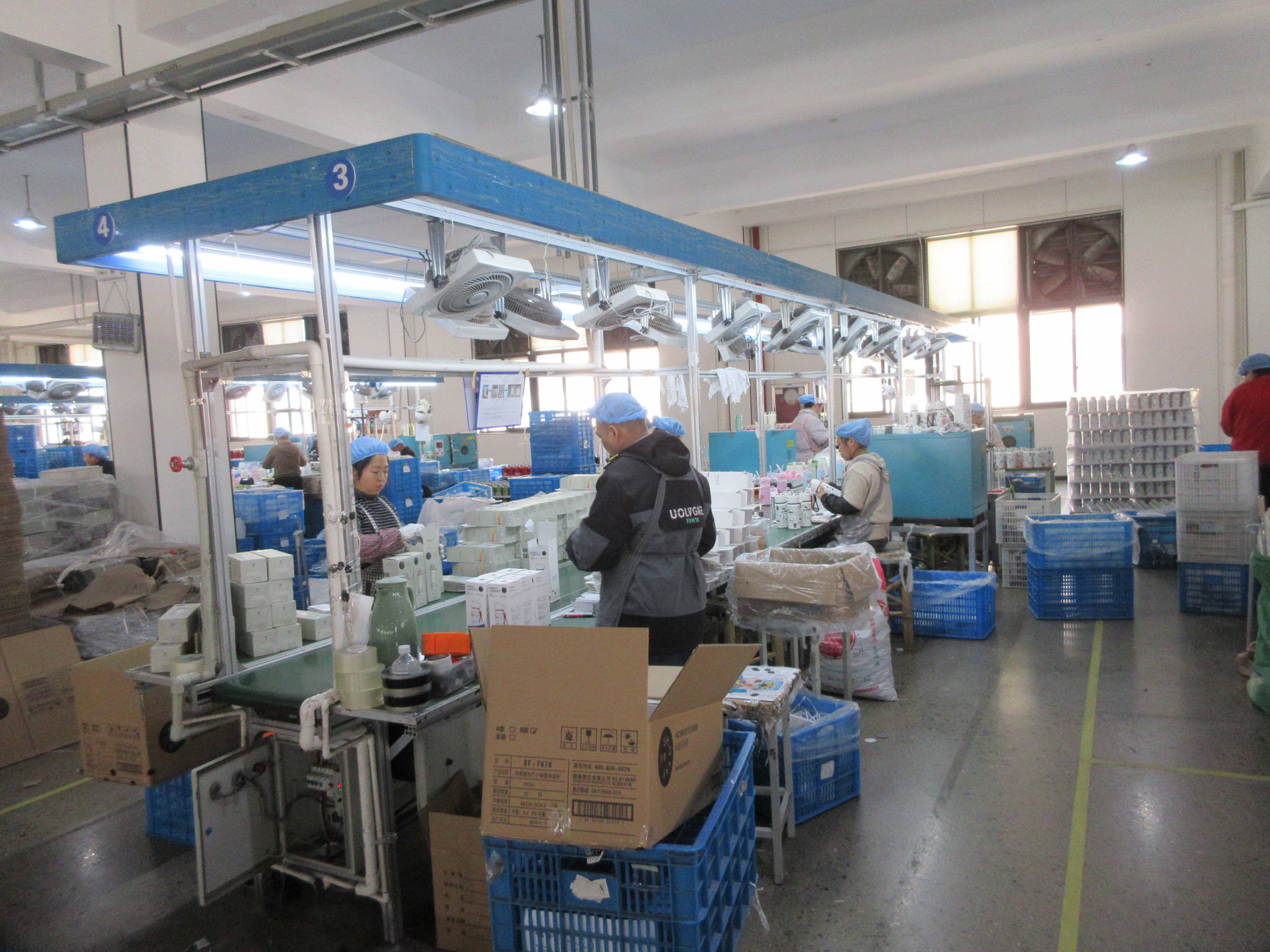 Workers on a production and inspection line checking and packing products in a factory